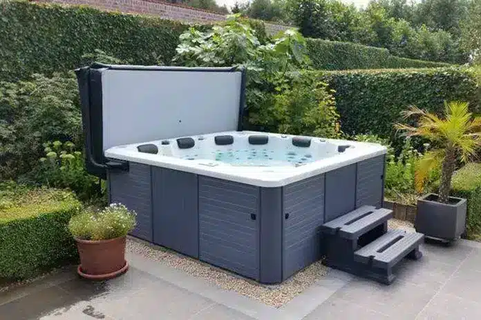 jacuzzi met een open cover en een opstaptrapje